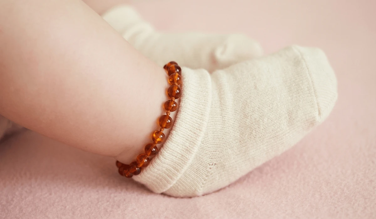 Baltic Amber Teething Bracelets: Understanding the Benefits, Science, and Tradition 2 - Buddha Bodhis Close-up of a Baltic amber anklet on an infant's ankle, showing proper skin contact and safety placement under a sock.