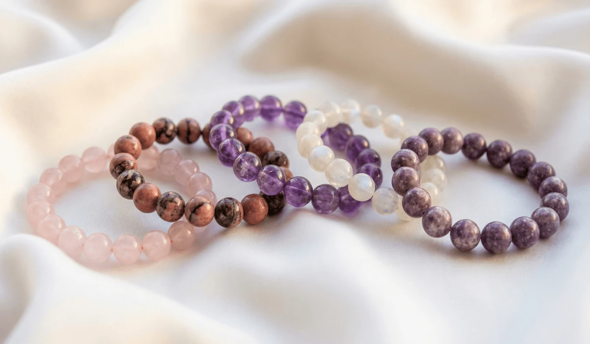 The Best Crystals for Self-Love, Confidence, and Inner Healing - Buddha Bodhis Top 5 crystal bracelets for self-love including Rose Quartz and Amethyst on white silk background.