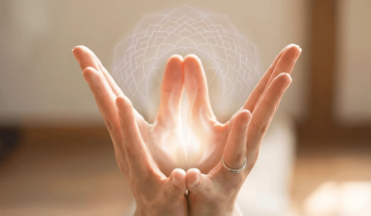 The Spiritual Meaning of the Lotus Flower: Finding Growth in the Mud 4 - Buddha Bodhis A meditative visualization of the Lotus Mudra hand gesture with glowing white energy, representing the Sahasrara crown chakra activation.