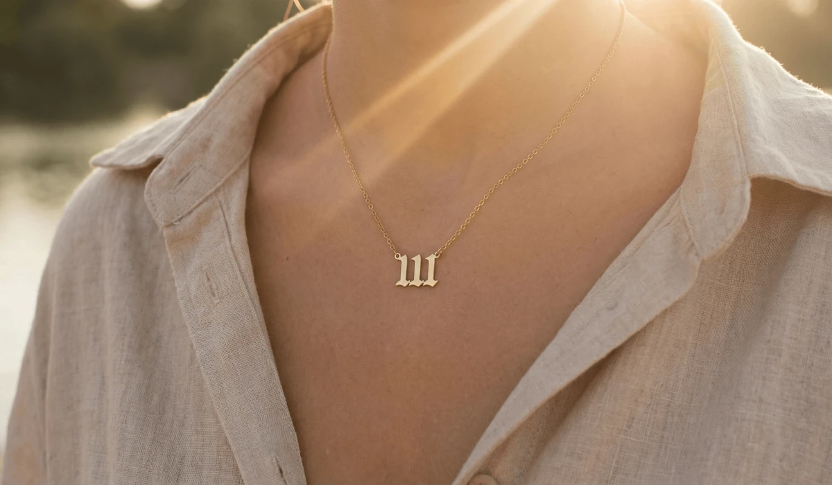 Understanding the Angel Number Jewelry Trend and Its Divine Meaning - Buddha Bodhis A dainty gold 111 angel number necklace representing manifestation and new beginnings worn by a woman in soft sunlight.