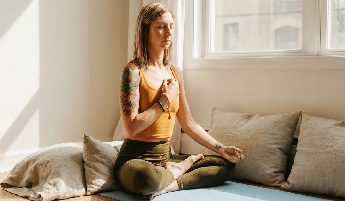 How to Set a Meaningful Intention for Your Meditation Bracelet 2 - Buddha Bodhis A woman performing an intention-setting ritual with her wrist mala bracelet in a sunlit room.