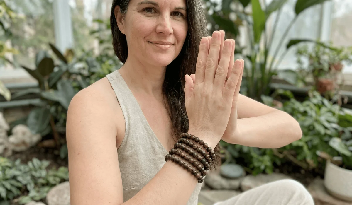The Significance of 108 Mala Beads: Meaning, Use, and the Power of Lignum Vitae 3 - Buddha Bodhis Person wearing a 108 Lignum Vitae mala necklace wrapped as a multi-layer bracelet for daily mindfulness and yoga practice.