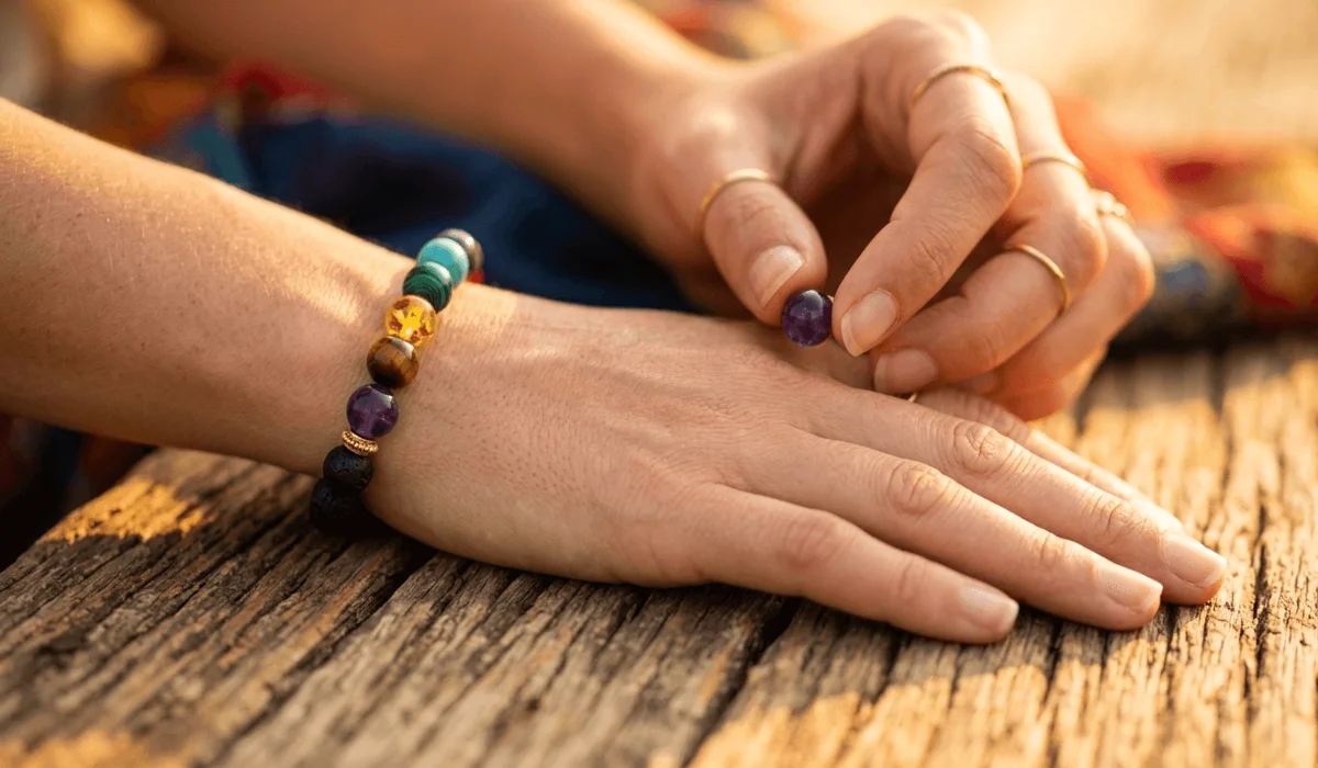 7 Chakra Bracelets for Women: A Guide to Finding Emotional Balance and Inner Peace 5 - Buddha Bodhis A woman wearing a chakra bracelet on her left wrist, practicing intention-setting for emotional balance.