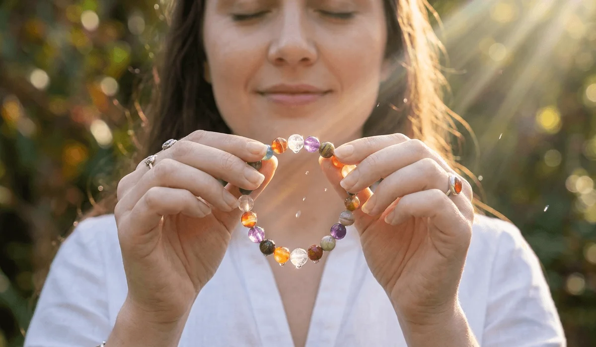 How to Cleanse Your Jewelry of Negative Energy: Safe & Practical Methods 4 - Buddha Bodhis Woman holding a gemstone bracelet near her heart space to activate personal intentions after cleansing.