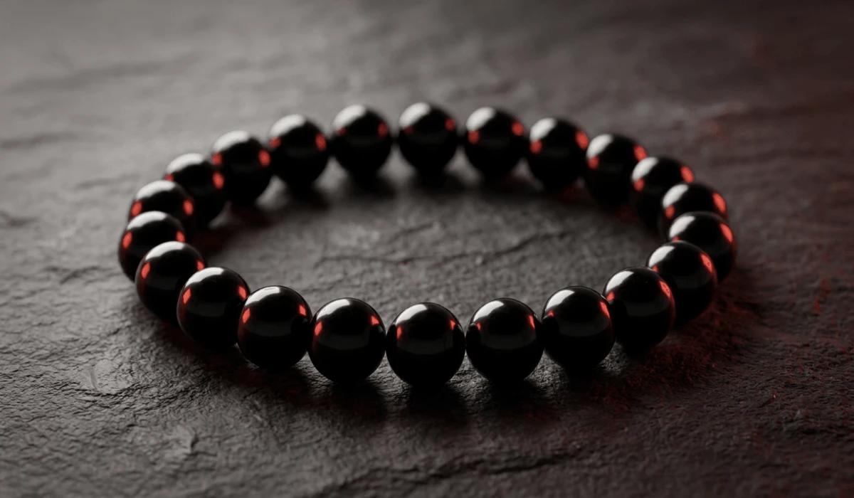 Black Obsidian Wrist Mala: Spiritual Protection, Meaning, and How to Wear - Buddha Bodhis Black Obsidian wrist mala beads for spiritual protection and root chakra grounding resting on a dark slate surface.