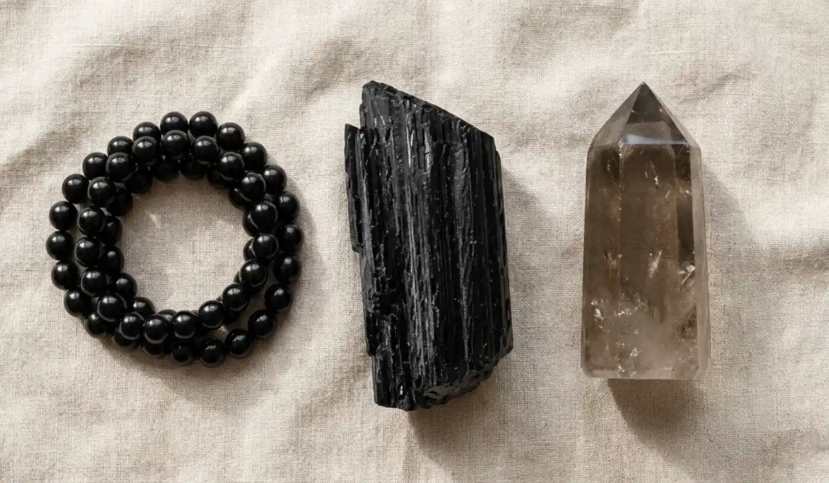 Black Obsidian Wrist Mala: Spiritual Protection, Meaning, and How to Wear 5 - Buddha Bodhis Visual comparison of smooth black obsidian wrist mala, raw black tourmaline, and smoky quartz crystals for energetic protection.