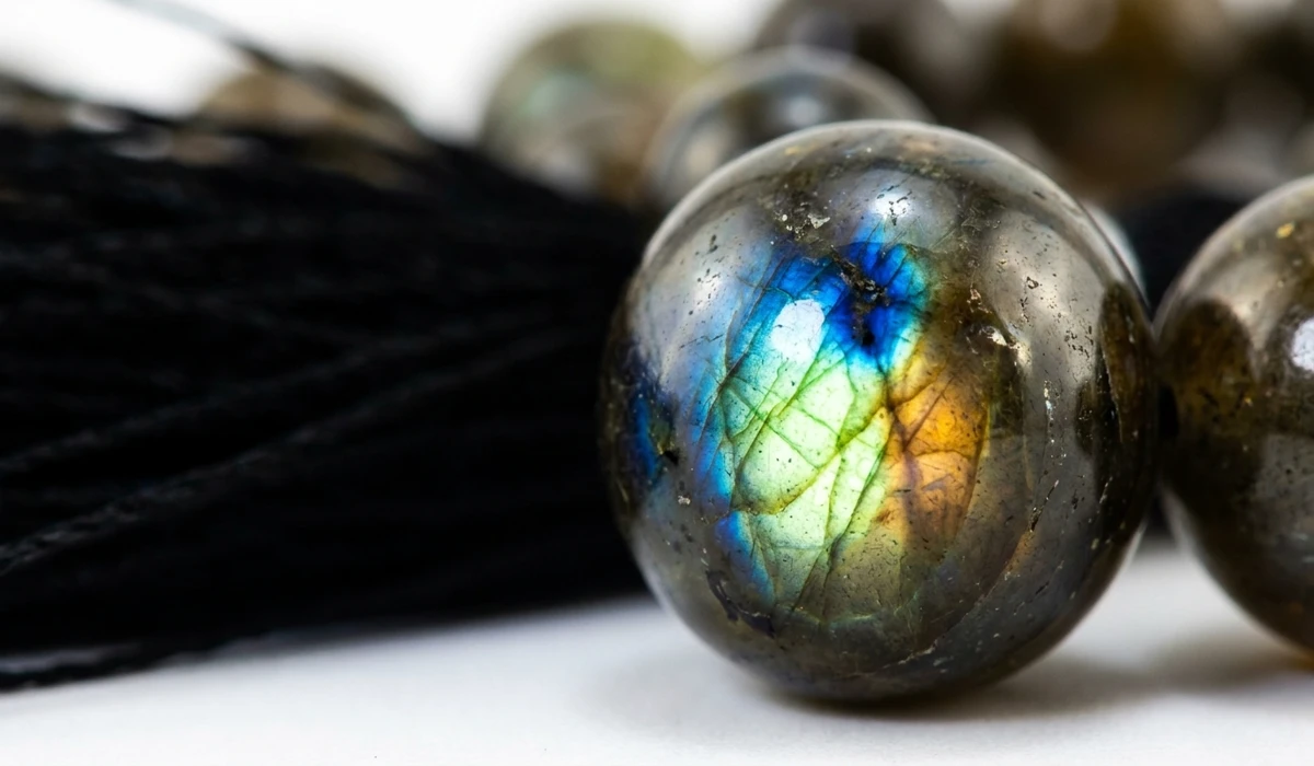 The Spiritual Meaning and Benefits of Labradorite Mala Beads for Meditation - Buddha Bodhis Macro photography of Labradorite mala beads showing brilliant blue and gold labradorescence flash and 108 bead structure.