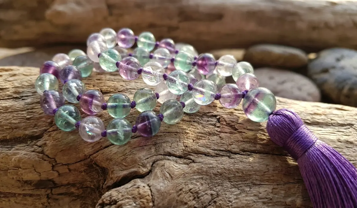 Fluorite Mala Beads: Spiritual Meaning and Benefits for Meditation - Buddha Bodhis A close-up of 108-bead Rainbow Fluorite mala beads showing natural purple and green gemstone banding.